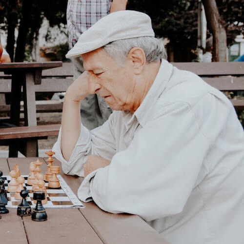 persona mayor jugando al ajedrez