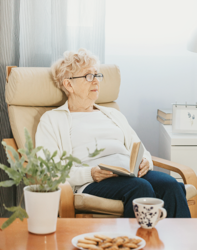 Mujer en una cómoda con un libro en sus manos